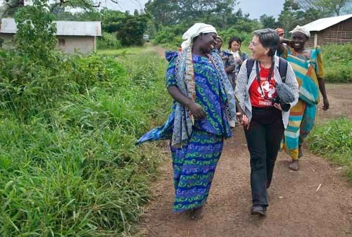 Mary Dailey Brown, front right, walks with a group of women in a village in Uganda, doing field research on a proposed SowHope project.